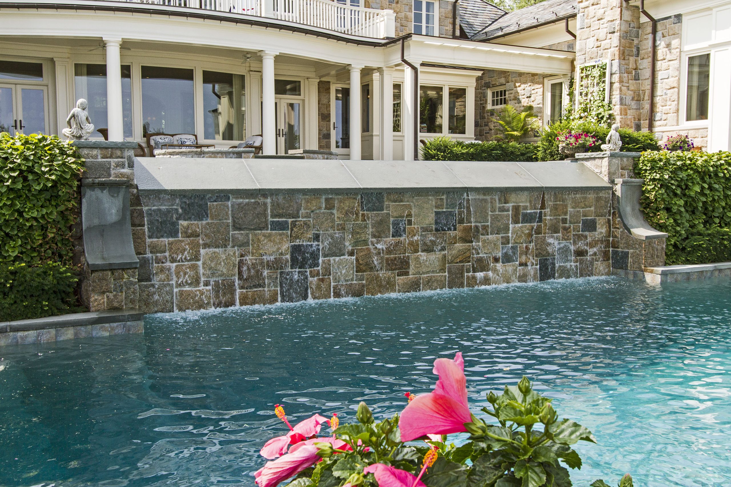 Gunite Pool Interior: The inside of this majestic pool is finished in a custom blend of “River Rok” pool plaster. This tough and time-resistant surface is intended to resemble Mother Nature in all her glory. The decking and coping around the pool are New York State bluestone. 